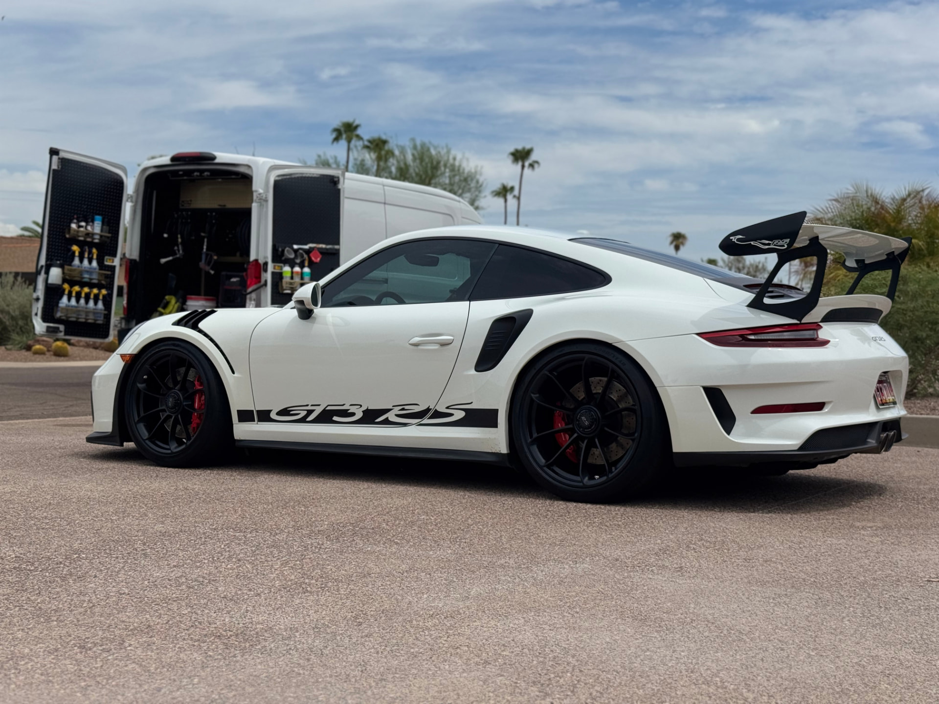 White Porsche 911 GT3 RS with Oasis Car Detailing mobile van in the background